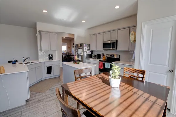 a kitchen with a table chairs sink and cabinets