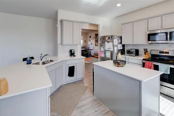 a kitchen that has a sink a stove top oven and refrigerator