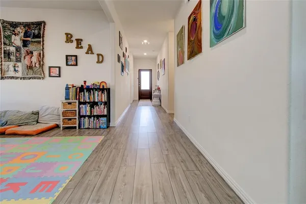 a view of a hallway with wooden floor and furniture