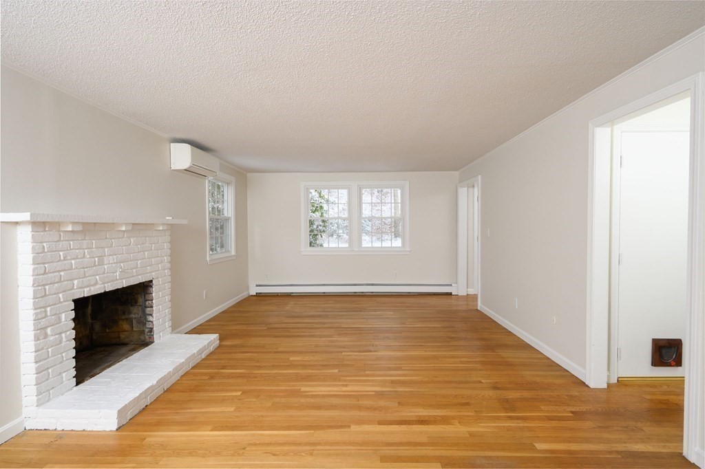 571 Main Street Marshfield, MA 02050 - Photo 11 of 25 a view of an empty room with a fireplace and a window
