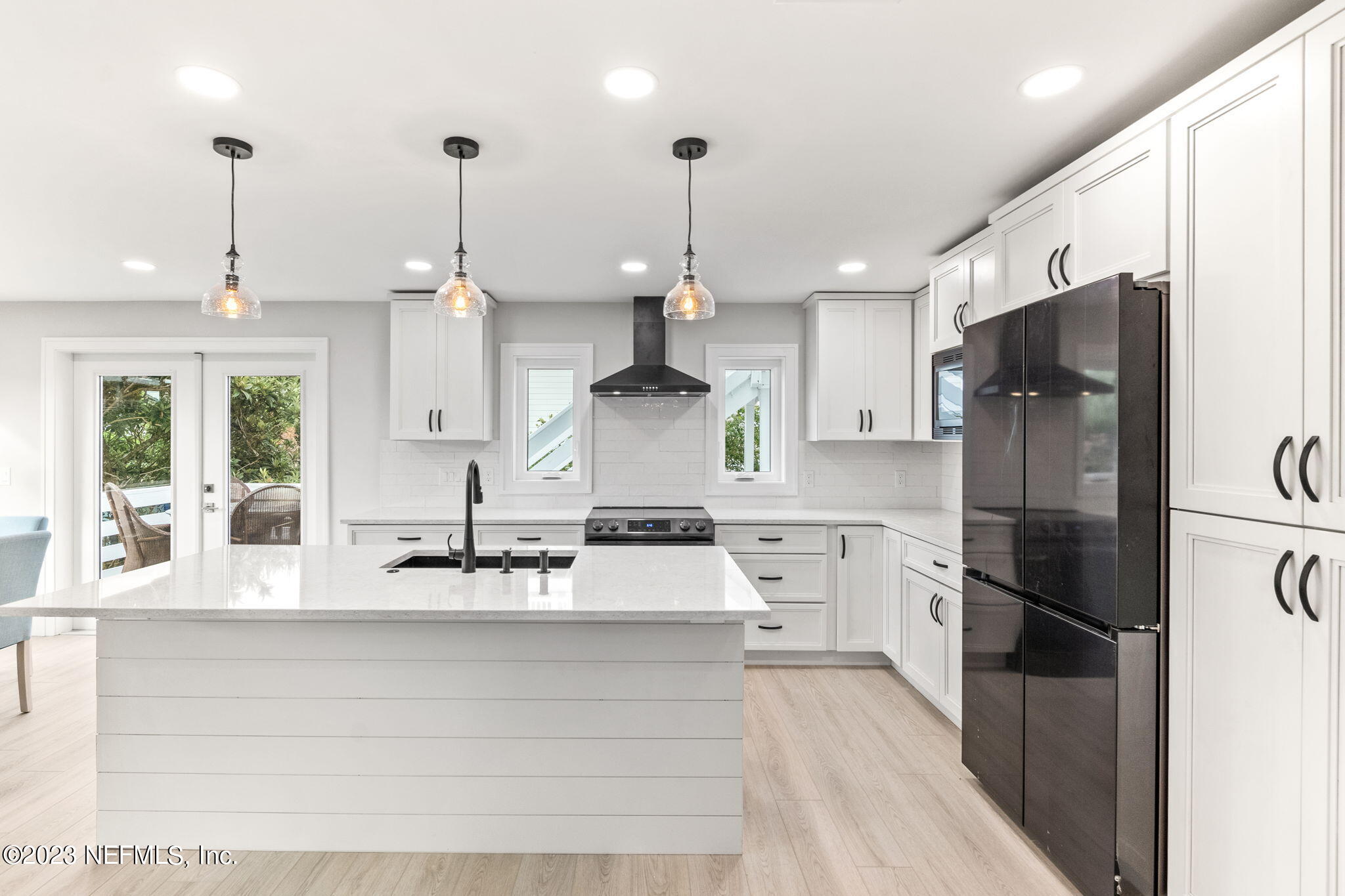 5348 Pelican Way St. Augustine, FL 32080 - Photo 27 of 58 a large kitchen with stainless steel appliances kitchen island granite countertop a refrigerator a stove a sink and a center island