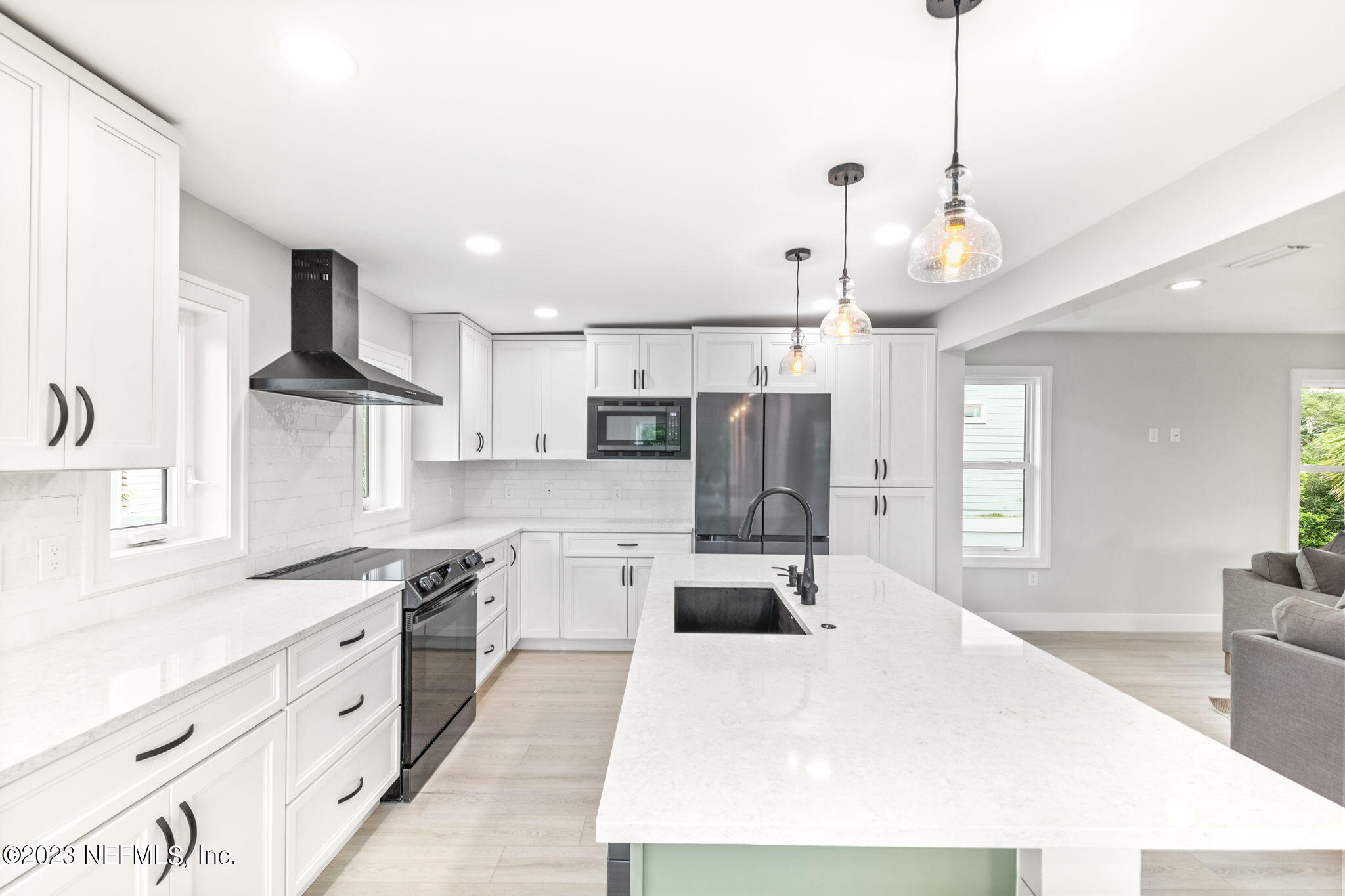 5348 Pelican Way St. Augustine, FL 32080 - Photo 31 of 58 a large kitchen with stainless steel appliances kitchen island granite countertop a refrigerator a stove a sink dishwasher a dining table and chairs with wooden floor