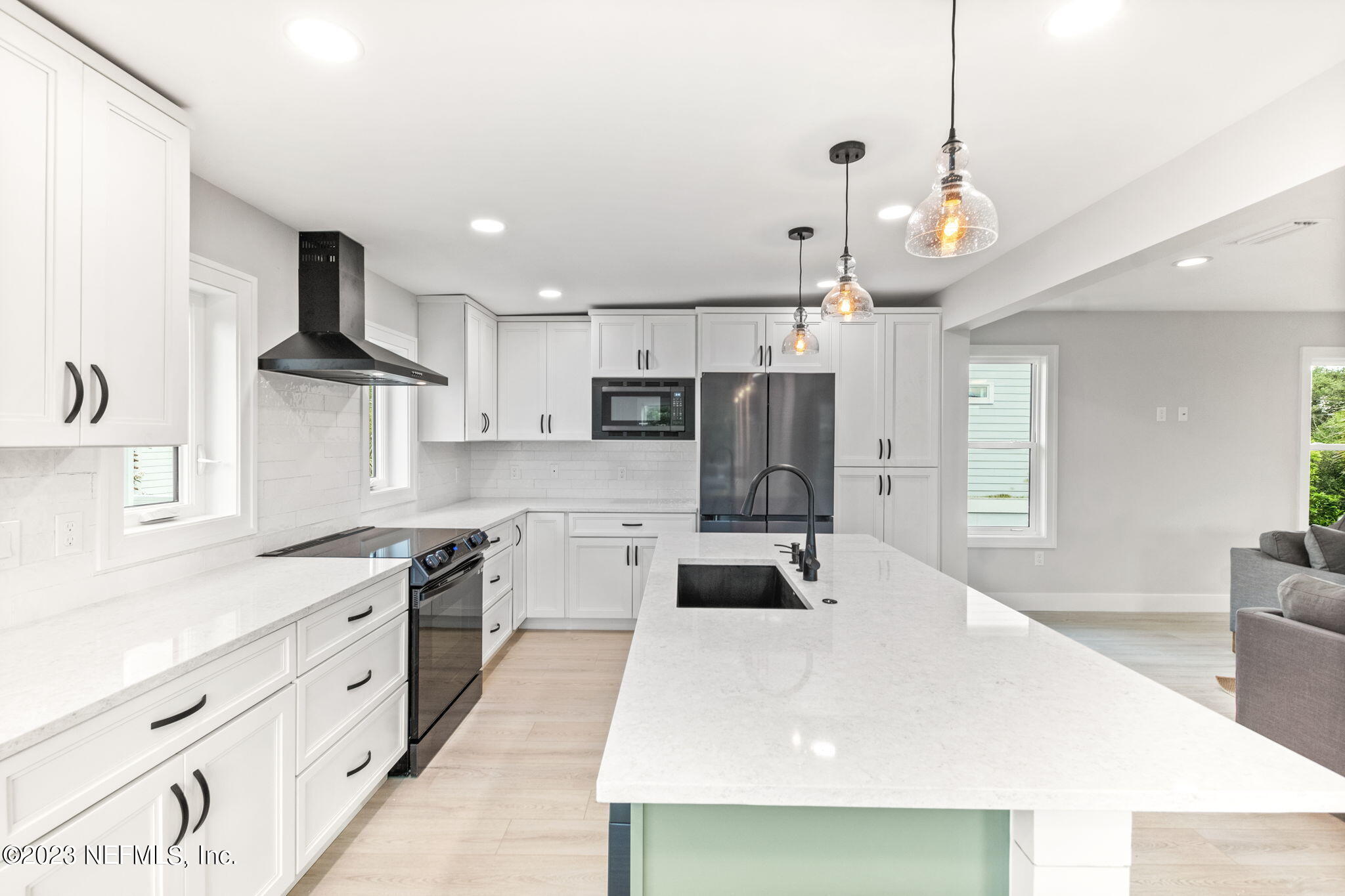 5348 Pelican Way St. Augustine, FL 32080 - Photo 34 of 58 a large white kitchen with stainless steel appliances kitchen island granite countertop a stove a sink a refrigerator and a refrigerator