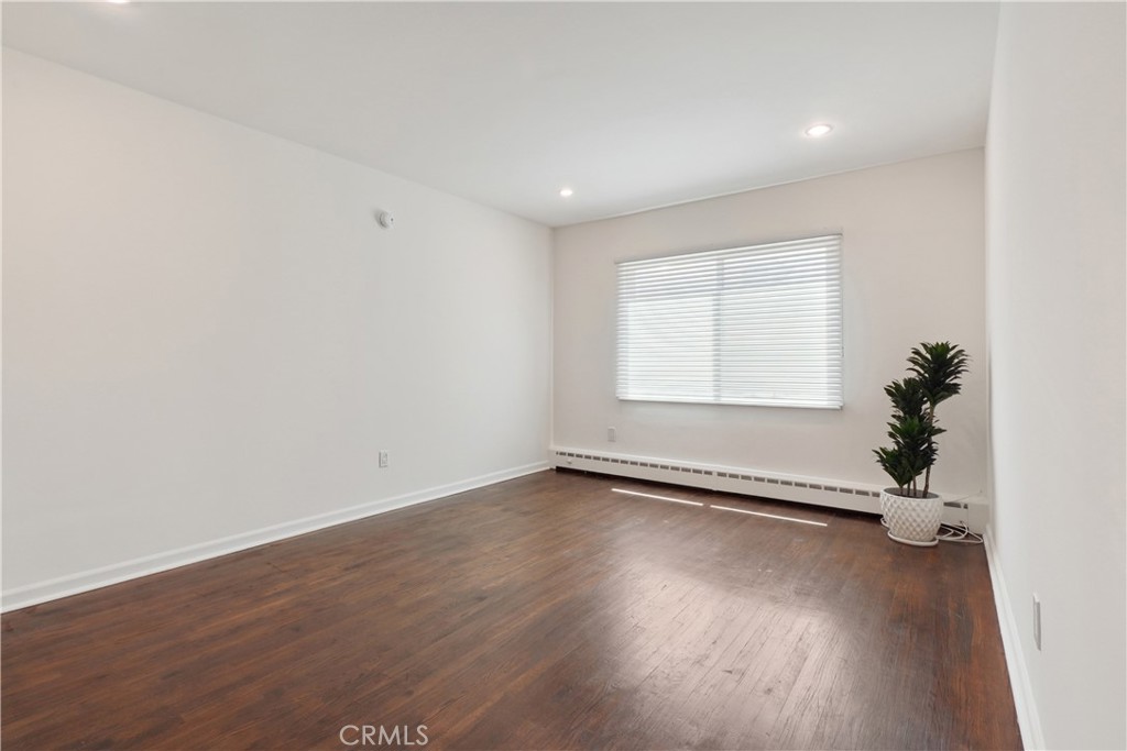 11767 Sunset Boulevard, Unit 202 Los Angeles, CA 90049 - Photo 15 of 22 an empty room with wooden floor and windows