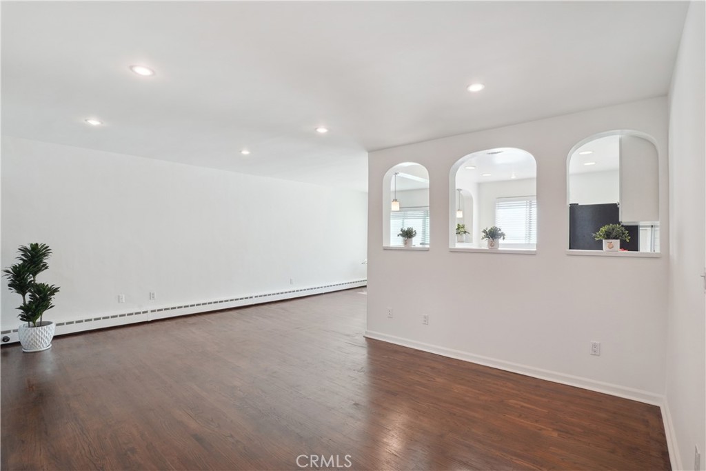 11767 Sunset Boulevard, Unit 202 Los Angeles, CA 90049 - Photo 7 of 22 an empty room with wooden floor and mirror