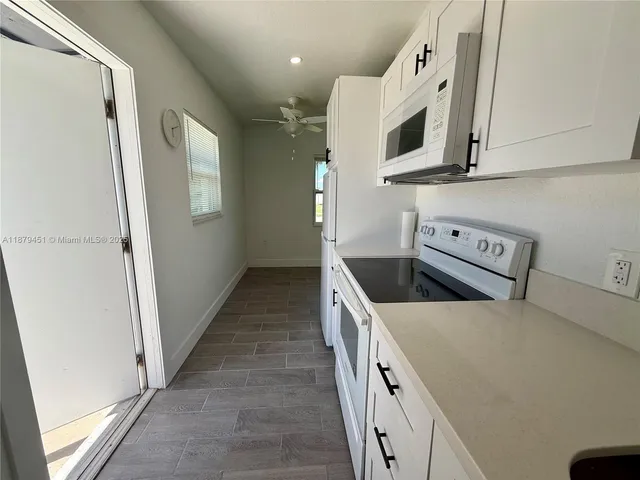 a kitchen with appliances a microwave and cabinets