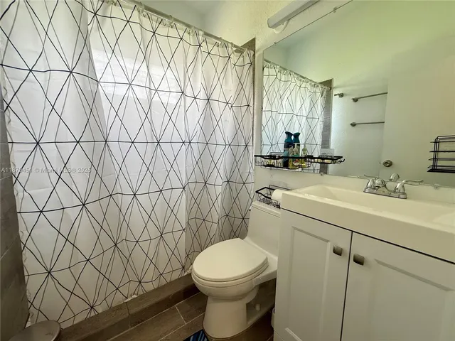 a bathroom with a sink toilet vanity and shower