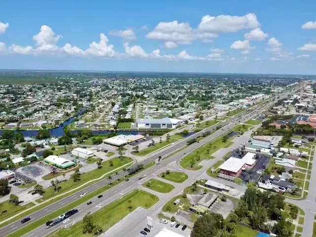 an aerial view of residential houses with outdoor space and parking