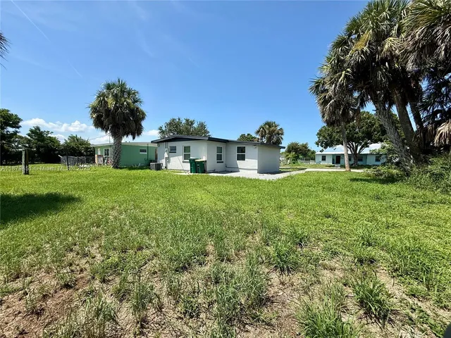 a view of a house with a yard and a garden
