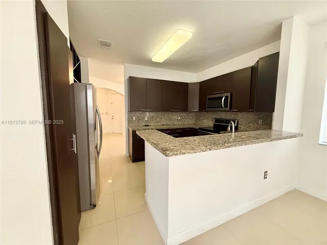 a kitchen with stainless steel appliances granite countertop a refrigerator and a sink