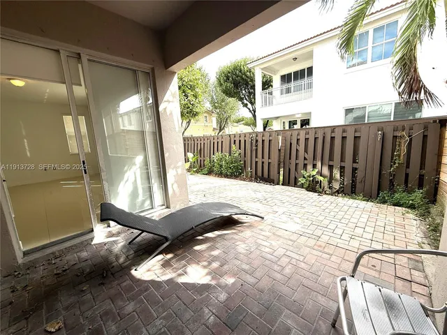 a view of backyard with large trees and wooden fence