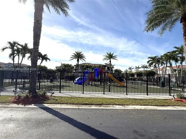 a view of a house with a cars park side of a road