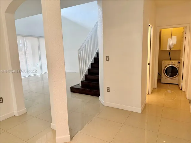 a view of a hallway to rooms and stairs