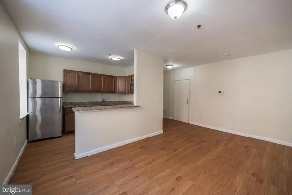 a view of kitchen with a sink refrigerator and wooden floor