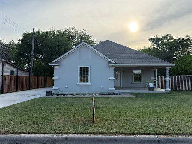 a front view of a house with a garden and yard