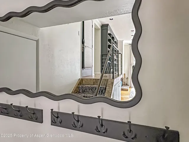 a bedroom with a bed a painting on the wall and a large window