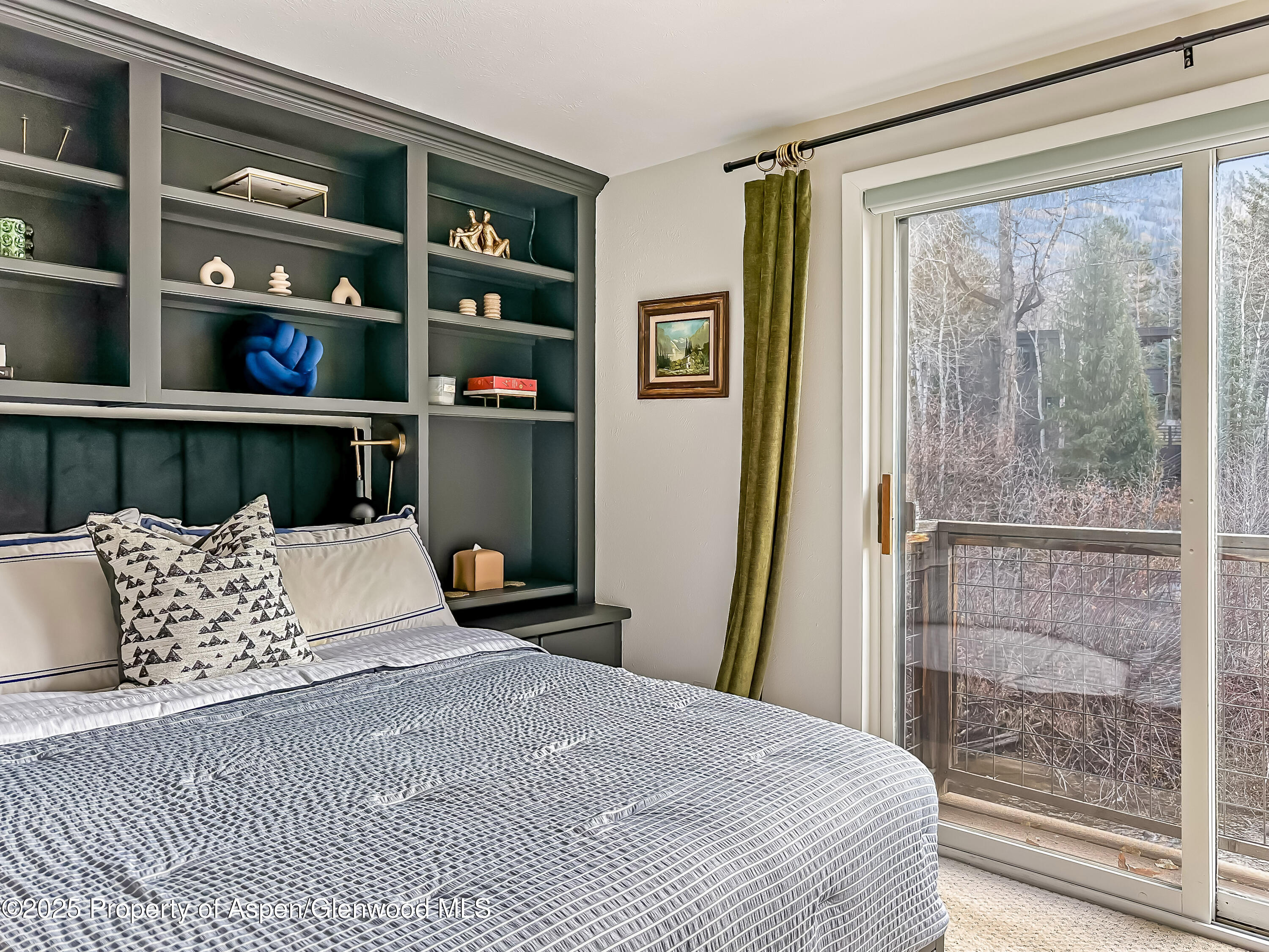 1050 Waters Avenue, Unit 9 Aspen, CO 81611 - Photo 12 of 19 a bedroom with a bed a painting on the wall and a large window