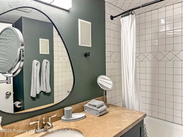 a bathroom with a granite countertop sink and a mirror