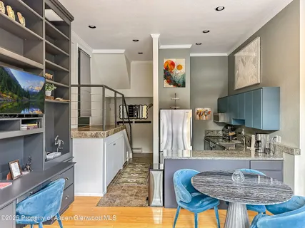 a kitchen with stainless steel appliances granite countertop a refrigerator a stove and a sink with wooden cabinets