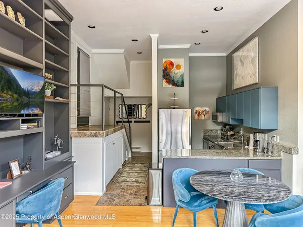 a kitchen with stainless steel appliances granite countertop a refrigerator a stove and a sink with wooden cabinets