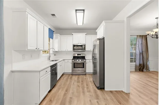 a kitchen with a refrigerator a stove top oven and wooden floor