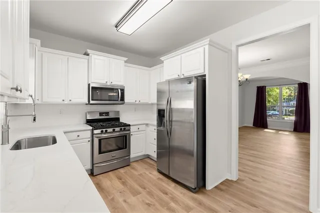 a kitchen with granite countertop a refrigerator stove and sink