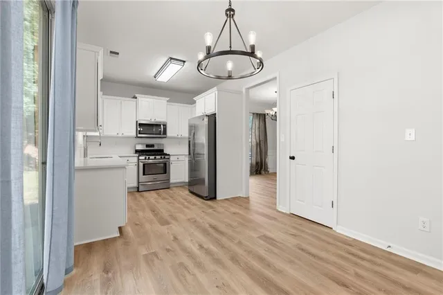 a view of a kitchen with refrigerator and microwave