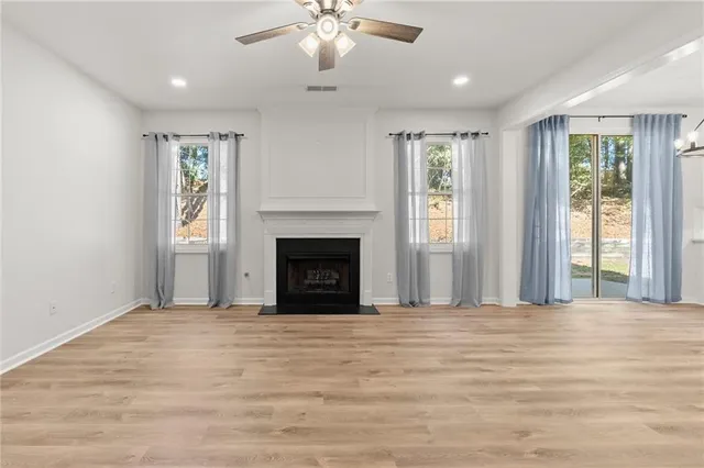 a view of an empty room with window and fire place