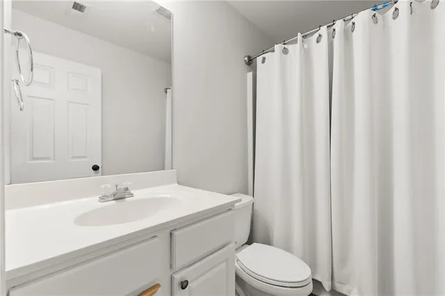 a bathroom with a sink a toilet and shower curtain