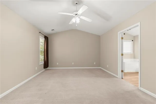 an empty room with fan and windows