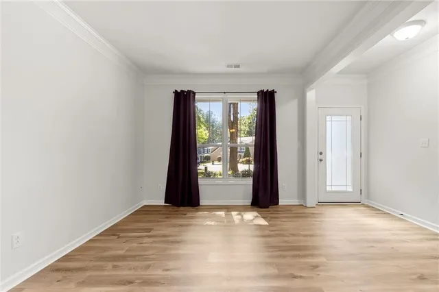 an empty room with window and wooden floor