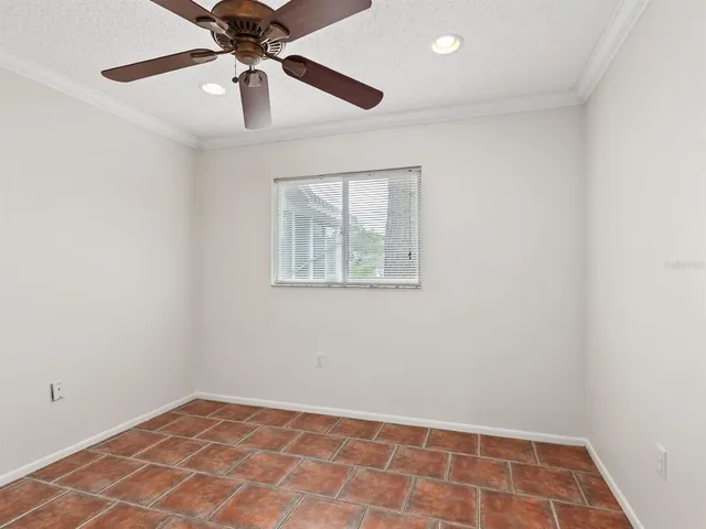an empty room with a window and a fan