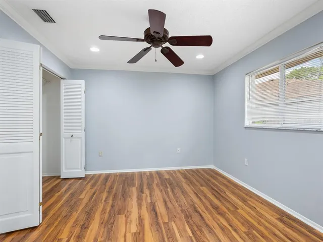 a view of empty room with wooden floor and window