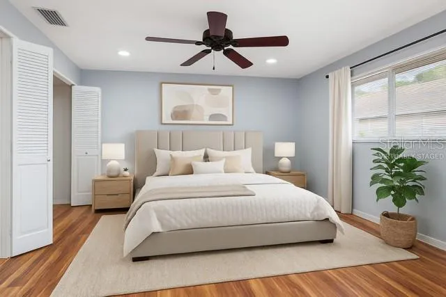 a bedroom with a bed lamp and a potted plant
