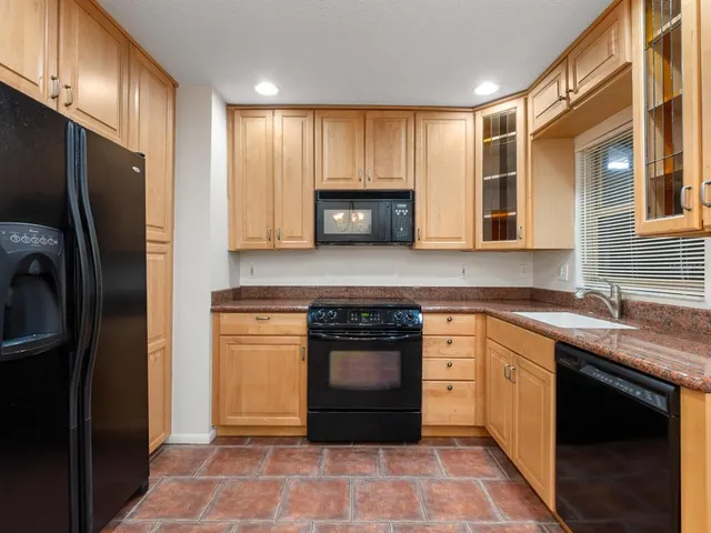 a kitchen with stainless steel appliances granite countertop a stove a sink and a refrigerator