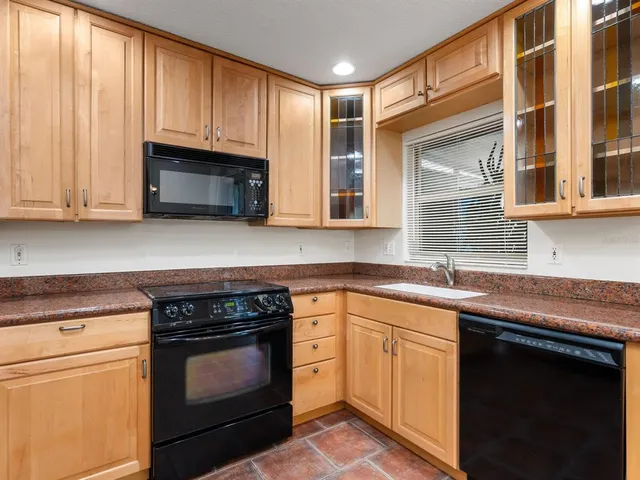 a kitchen with stainless steel appliances granite countertop a sink a stove and cabinets