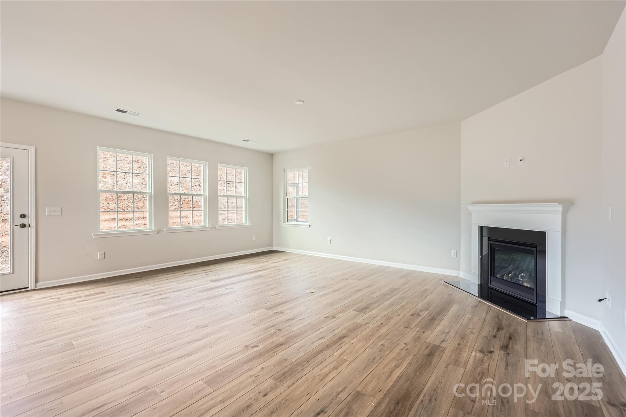 5932 Oak Br Circle Maiden, NC 28650 - Photo 4 of 13 an empty room with wooden floor fireplace and windows