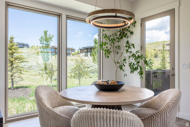 140 West Vista Road Kamas, UT 84036 - Photo 32 of 101 Spacious dining area featuring large windows, a glass-paneled exterior door, and a modern circular chandelier
