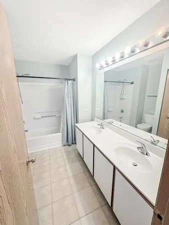 a bathroom with a double vanity sink mirror and shower
