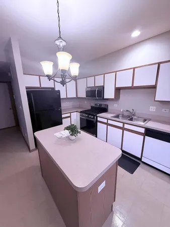 a kitchen with stainless steel appliances kitchen island granite countertop a sink a stove and a wooden cabinets