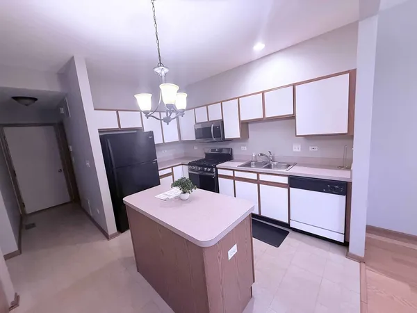 a kitchen that has a lot of cabinets in it and stainless steel appliances