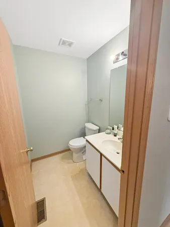 a spacious bathroom with a sink a toilet and a mirror