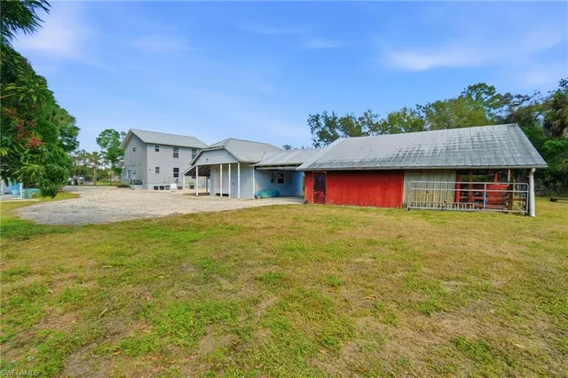 a front view of house with yard and trees in the background