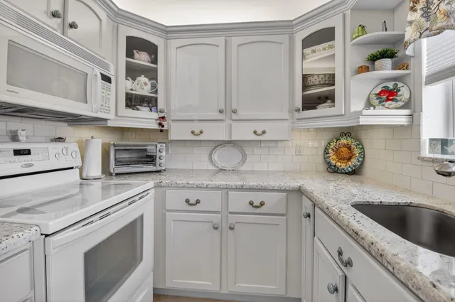 a kitchen with stainless steel appliances granite countertop a sink a stove and cabinets