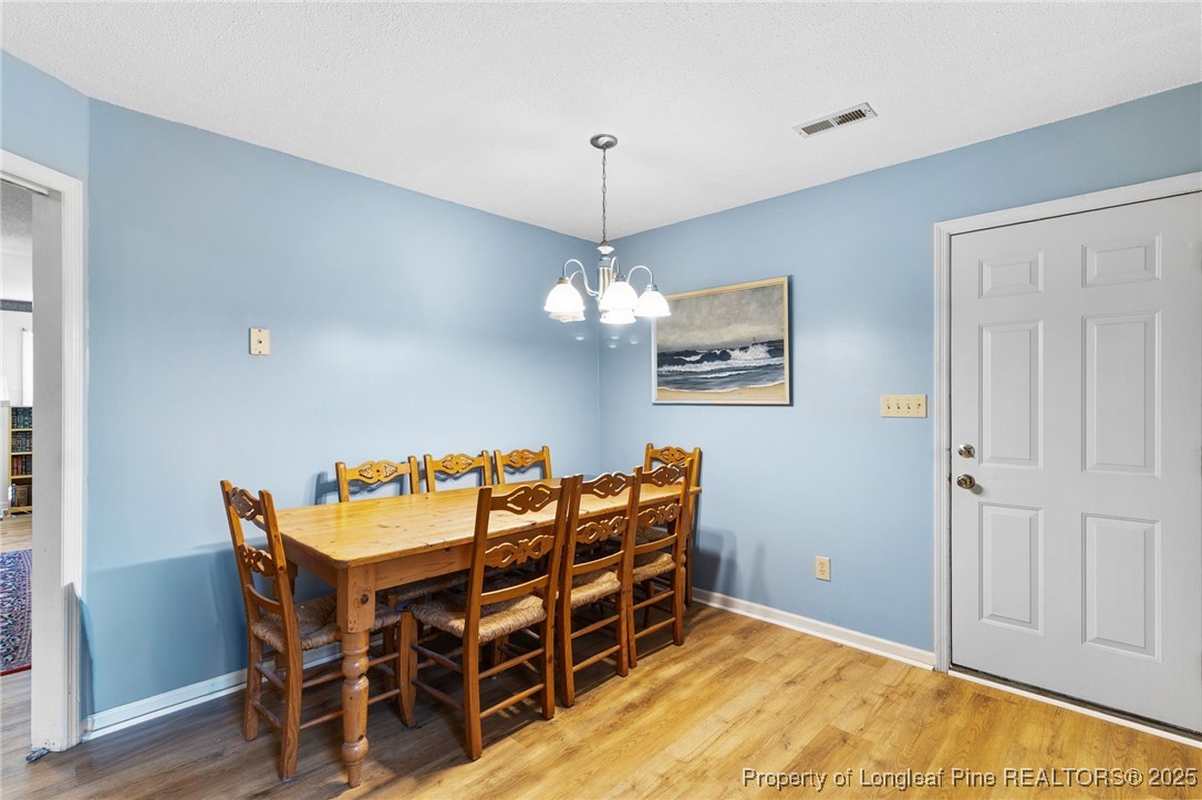 1132 Hoke Loop Road Fayetteville, NC 28314 - Photo 12 of 29 a dining room with furniture and wooden floor