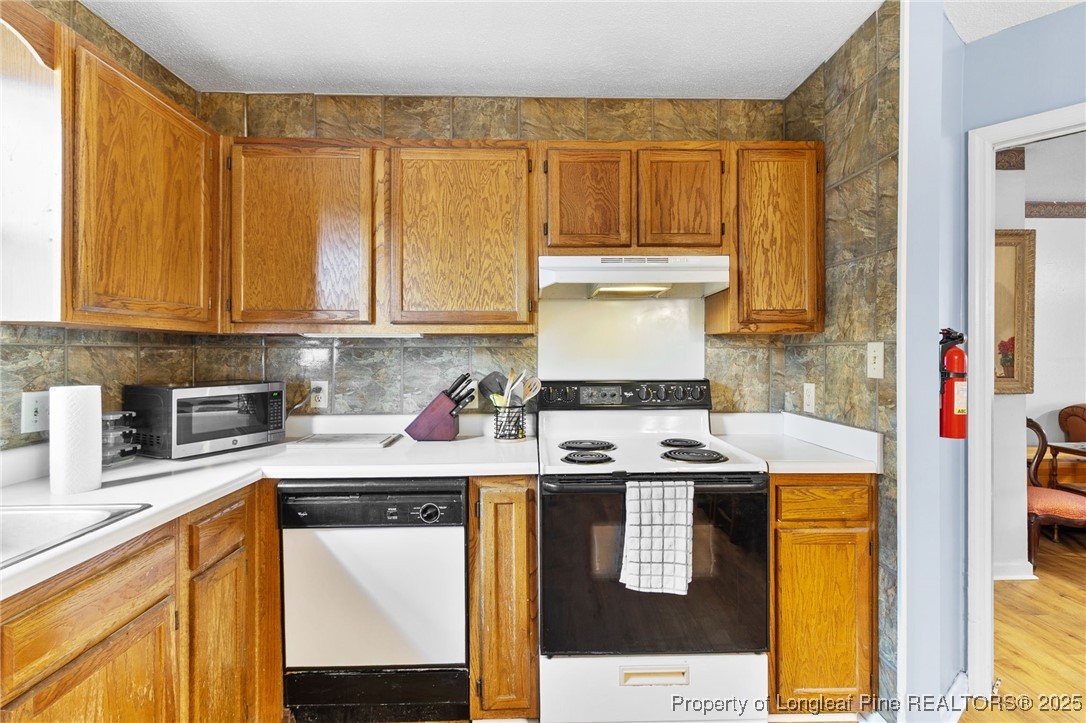 1132 Hoke Loop Road Fayetteville, NC 28314 - Photo 14 of 29 a kitchen with stainless steel appliances granite countertop a stove and a cabinets