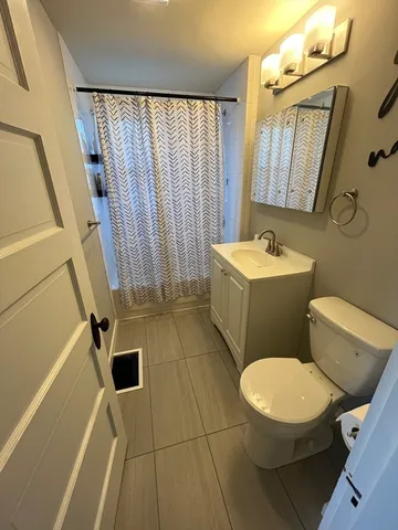 a white toilet sitting next to a bathroom sink and tub