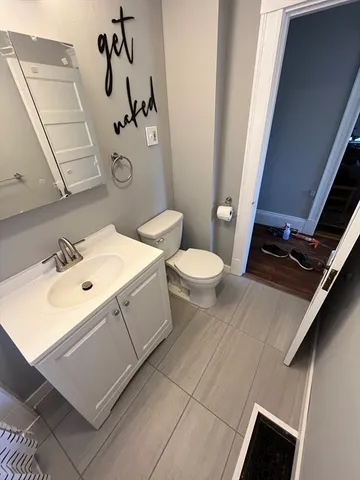 a bathroom with a sink mirror vanity and toilet