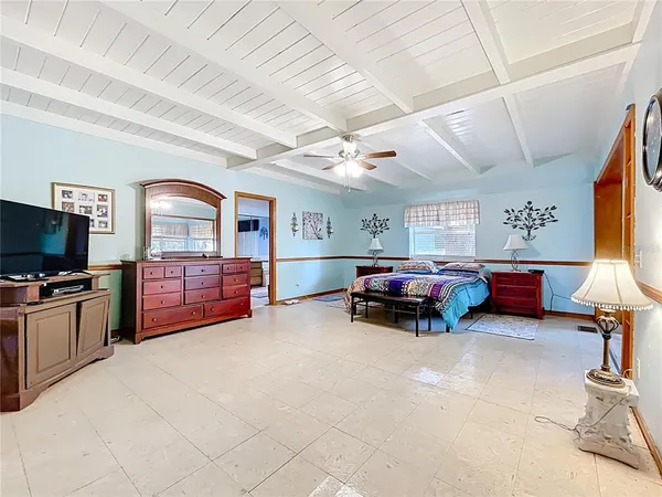 a bedroom with a large bed and a chandelier