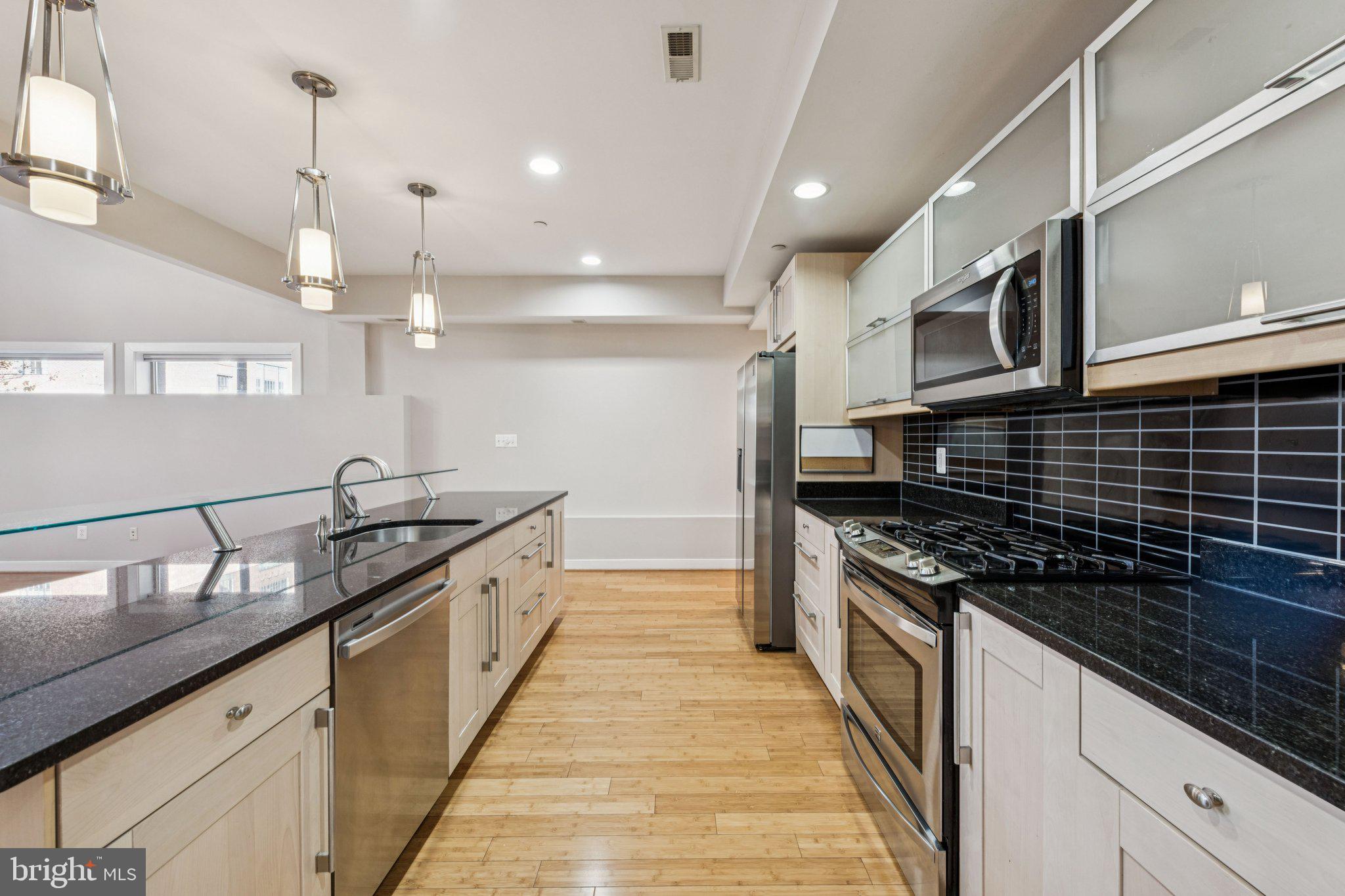 241 R Street Northeast, Unit A Washington, DC 20002 - Photo 11 of 33 a large kitchen with granite countertop a stove and a sink